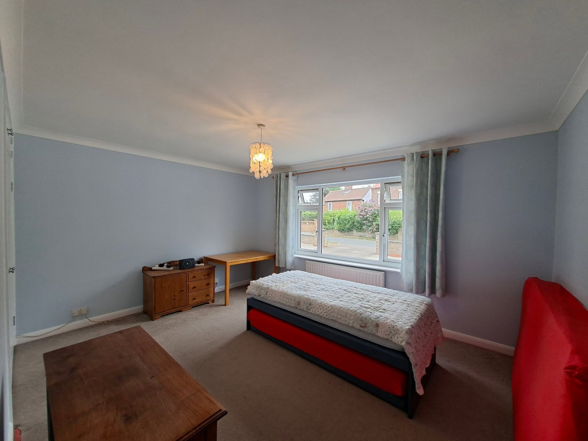 The same bedroom after decorating: pale blue walls, a white ceiling and white woodwork