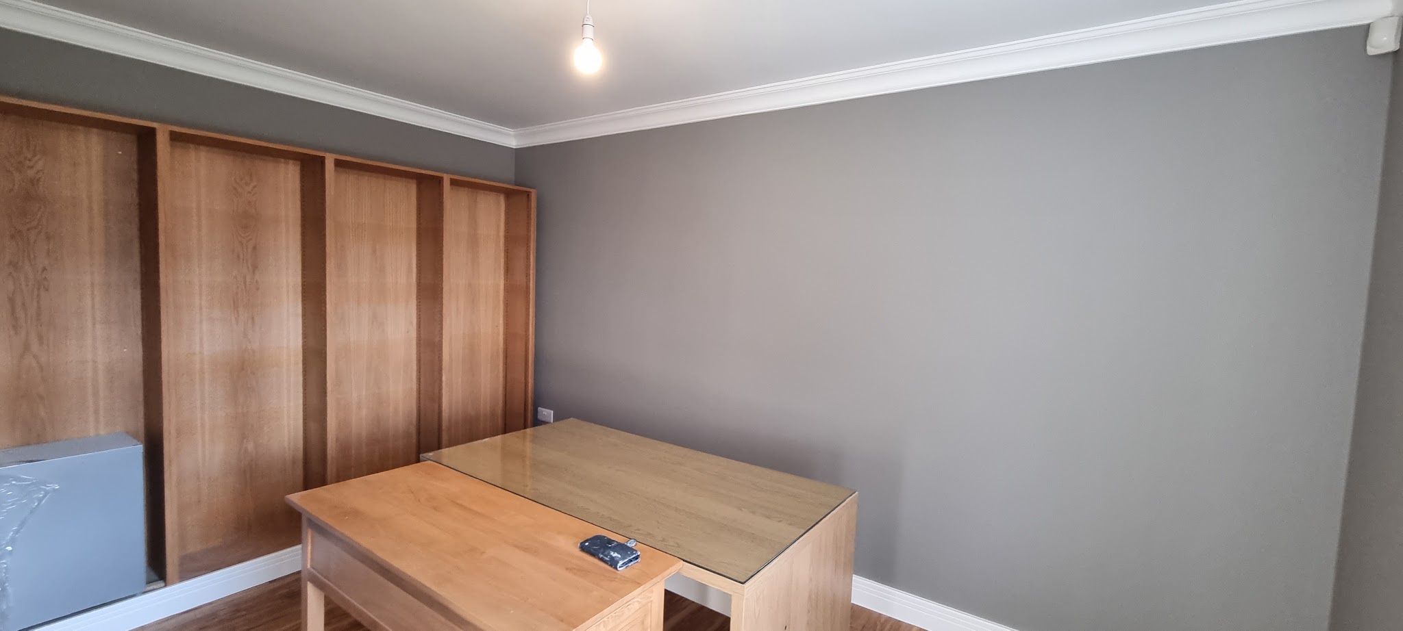 Room with grey walls and oak built-in wardrobes and desk
